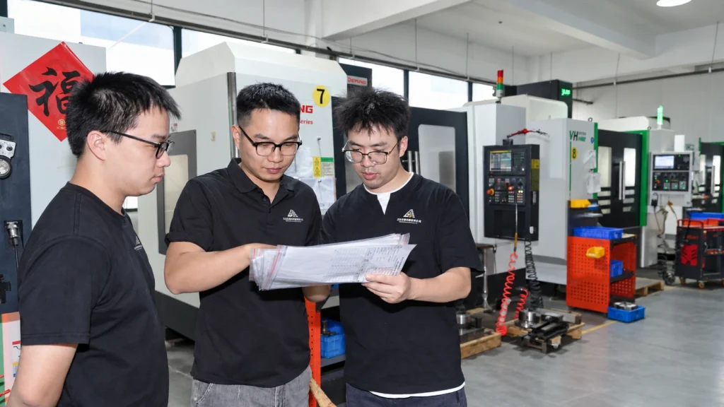 Lu Xun discussing technical drawings with the AYBERK manufacturing team